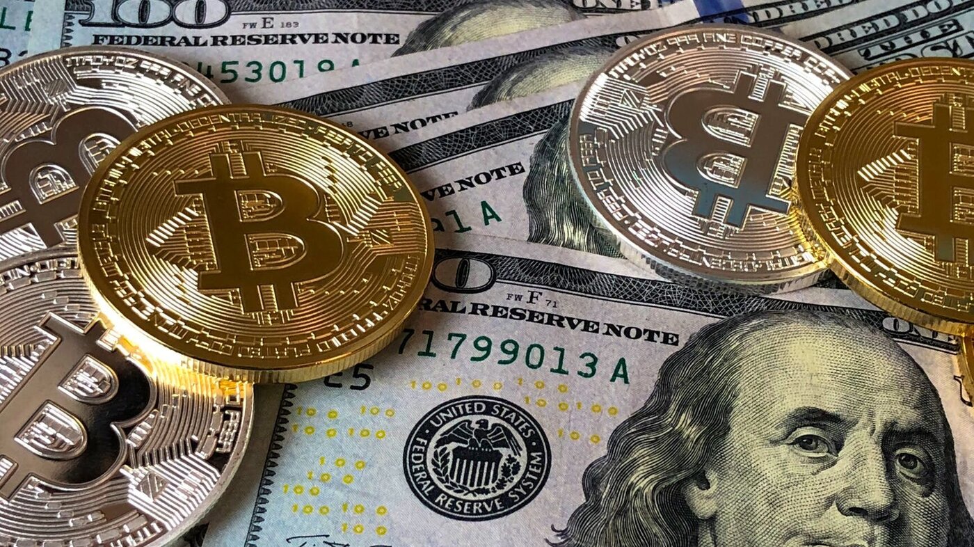 Bitcoins scattered on dollar bills
