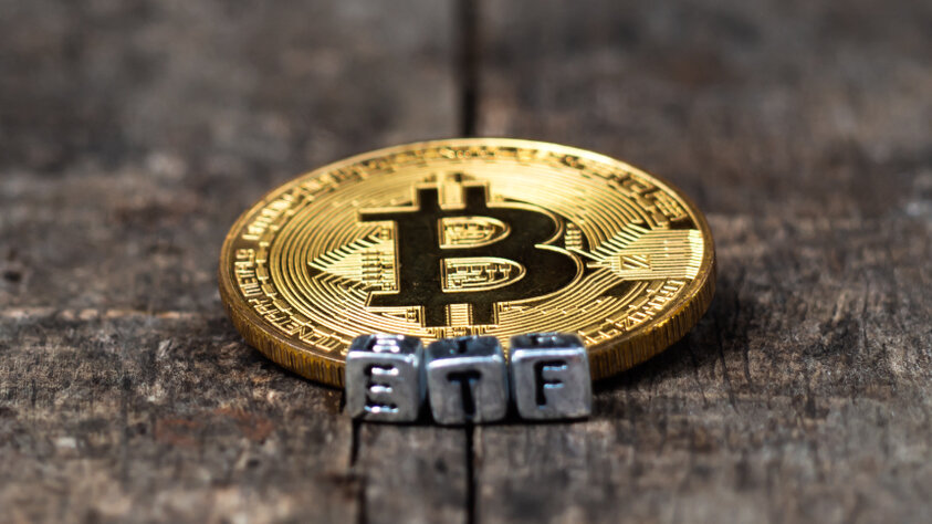 A Bitcoin coin next to ETF letters