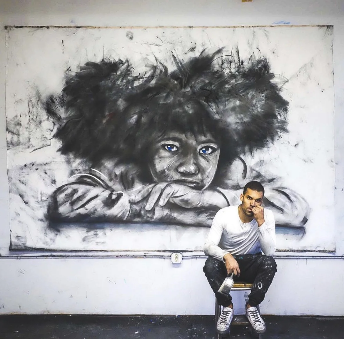 Artist Micah Johnson pictured in front of one of his works.